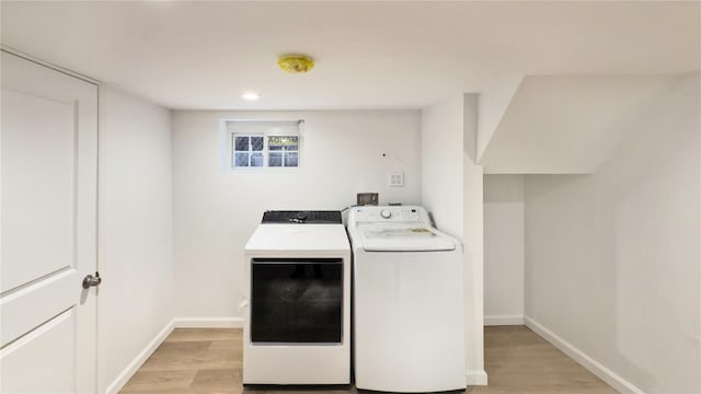 laundry area featuring light wood-type flooring and separate washer and dryer