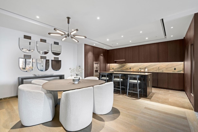 dining room featuring recessed lighting, a notable chandelier, and light wood-style flooring