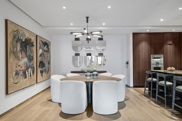 dining area featuring recessed lighting, a notable chandelier, and light wood finished floors