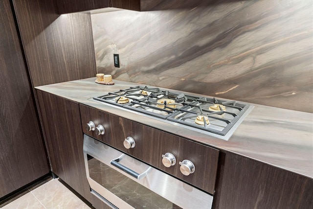 kitchen with stainless steel gas stovetop, light countertops, and dark brown cabinets