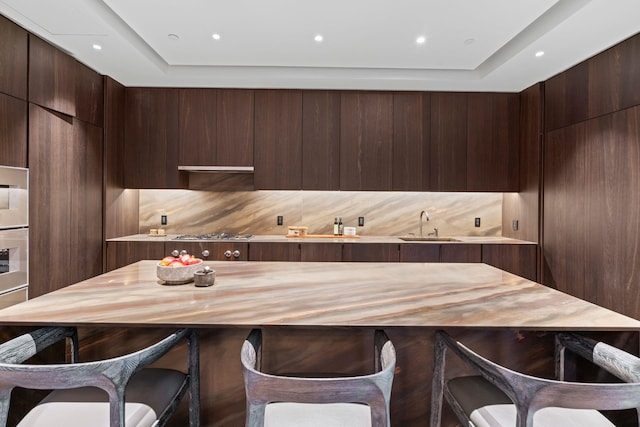 kitchen with modern cabinets, a sink, and dark brown cabinetry