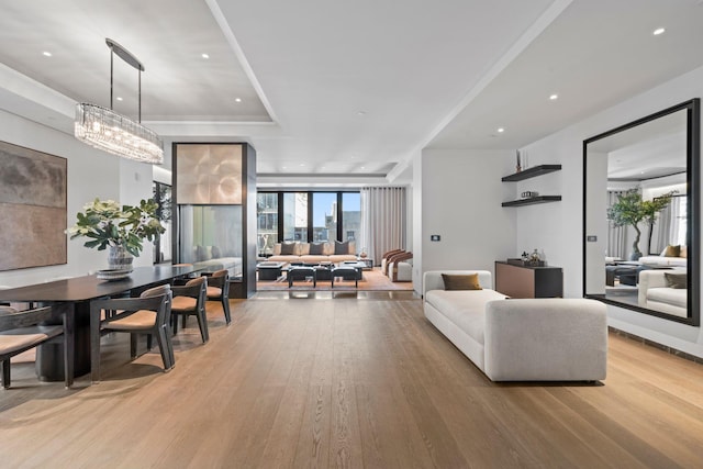 living area featuring light wood-style floors, a chandelier, and recessed lighting