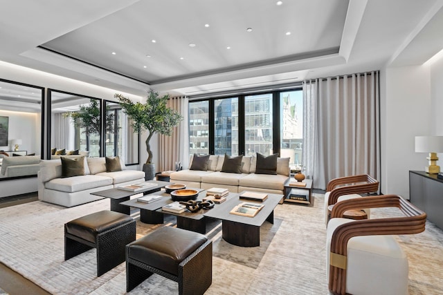 living area featuring a tray ceiling, recessed lighting, and floor to ceiling windows