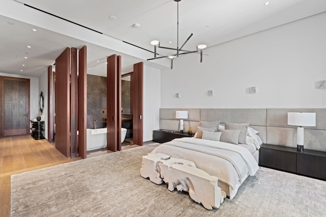 bedroom with a chandelier, wood finished floors, and recessed lighting