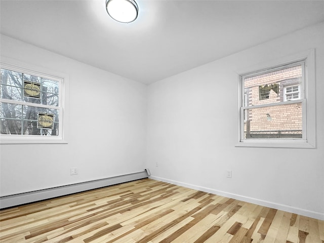 empty room featuring light wood-type flooring and baseboard heating