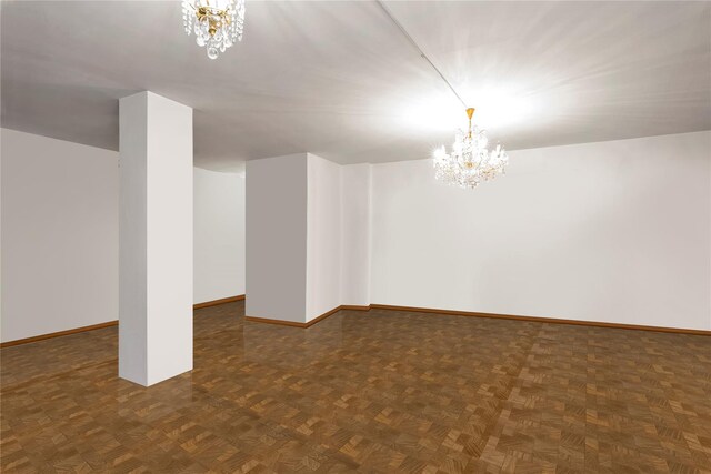 basement featuring dark parquet flooring and a chandelier