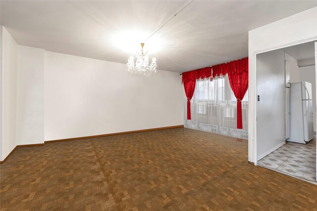 spare room with parquet floors and a notable chandelier