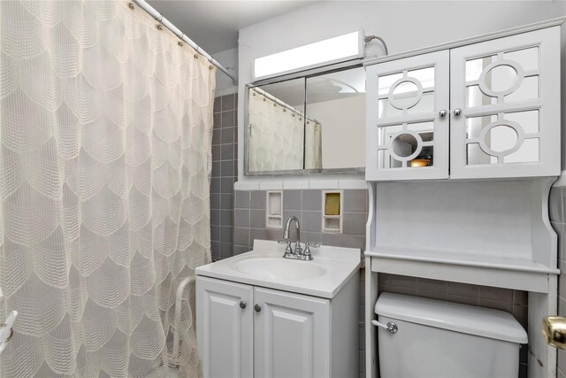 bathroom featuring backsplash, a shower with curtain, vanity, tile walls, and toilet