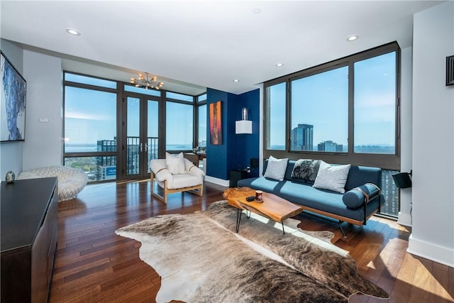 living room with dark hardwood / wood-style flooring, an inviting chandelier, and a wealth of natural light