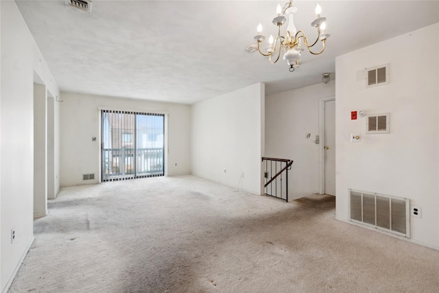 carpeted empty room featuring a notable chandelier