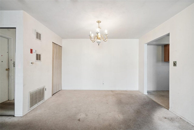 spare room with light colored carpet and a notable chandelier