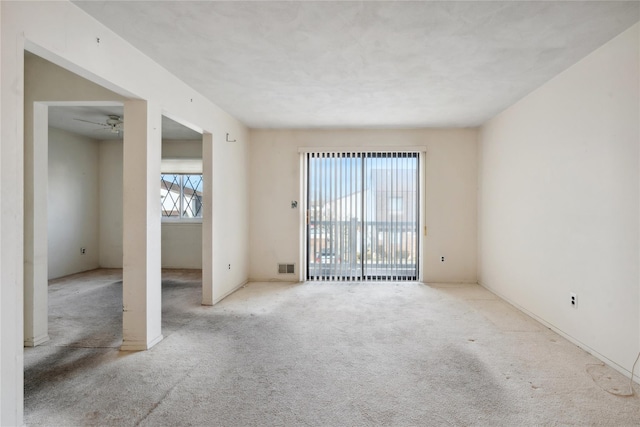 carpeted spare room featuring ceiling fan