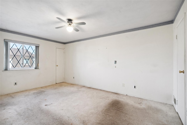 spare room featuring ceiling fan, light carpet, and ornamental molding