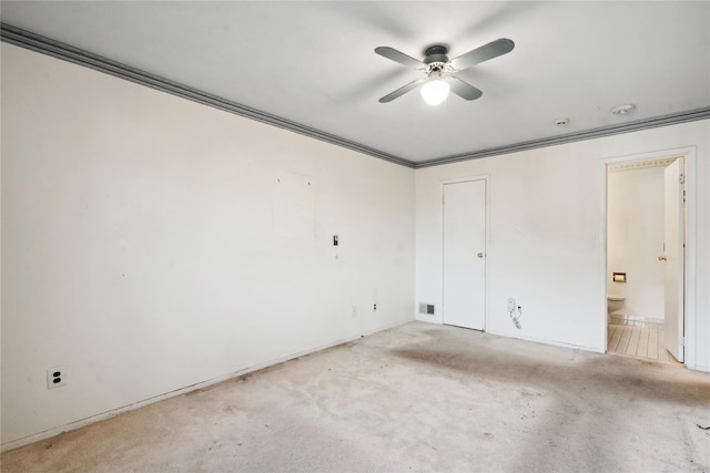 empty room featuring light carpet, ceiling fan, and ornamental molding