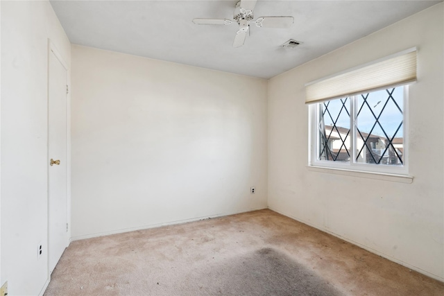 empty room featuring ceiling fan and light colored carpet