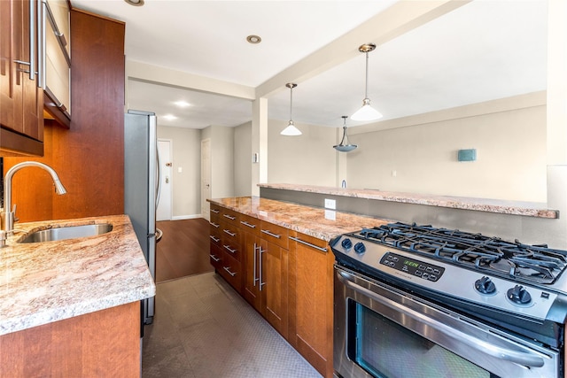 kitchen featuring light stone countertops, sink, hanging light fixtures, stainless steel appliances, and dark tile patterned flooring