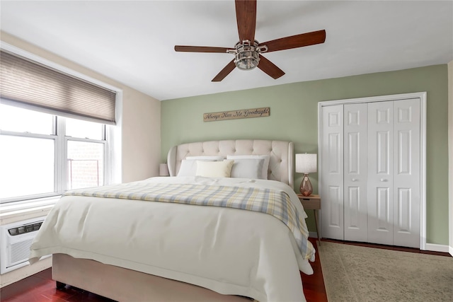 bedroom with a wall mounted air conditioner, a closet, ceiling fan, and dark hardwood / wood-style floors