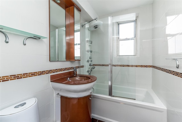 full bathroom with vanity, toilet, shower / bath combination with glass door, and tile walls