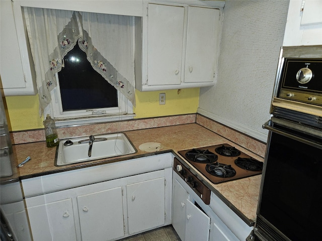 kitchen with white cabinets, oven, cooktop, and sink