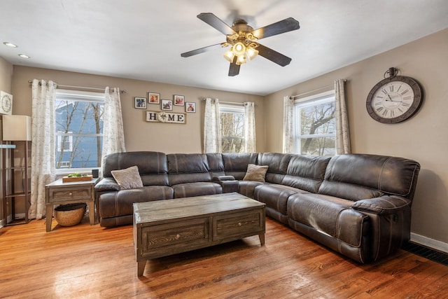 living room with hardwood / wood-style flooring, ceiling fan, and a wealth of natural light