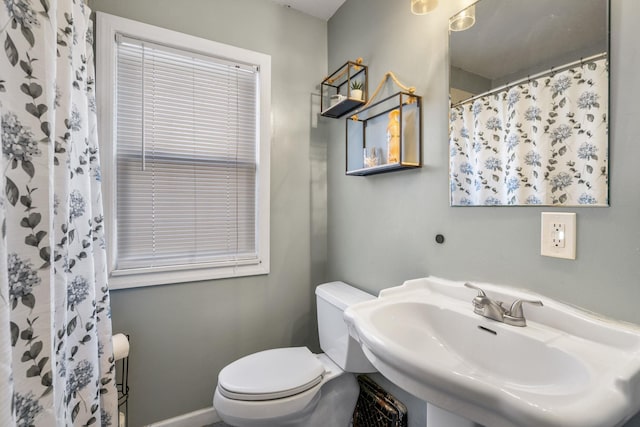 bathroom with sink, a shower with shower curtain, and toilet