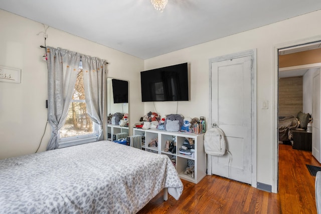 bedroom with dark hardwood / wood-style floors