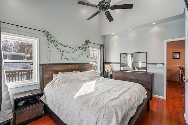 bedroom with ceiling fan, dark hardwood / wood-style floors, and multiple windows