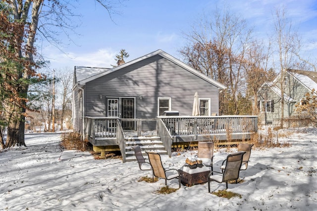 snow covered house with a wooden deck