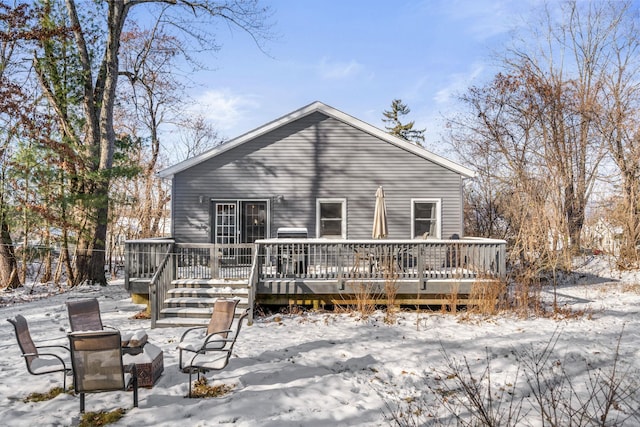 snow covered house featuring a deck