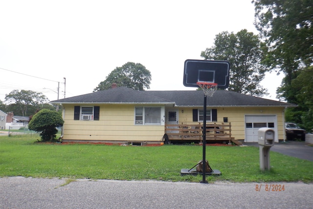 view of front of property with a garage, a deck, and a front lawn