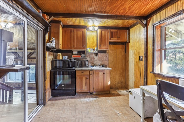 kitchen with sink, wooden ceiling, stove, wooden walls, and light parquet flooring