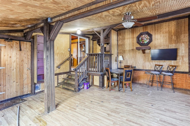 basement featuring wood walls, light hardwood / wood-style floors, and wood ceiling