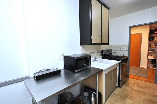 kitchen featuring decorative backsplash, sink, light wood-type flooring, and black range with gas cooktop