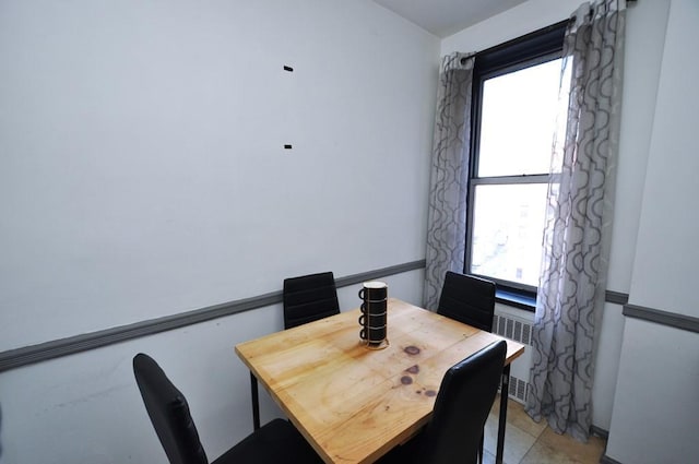 dining space with radiator and a healthy amount of sunlight