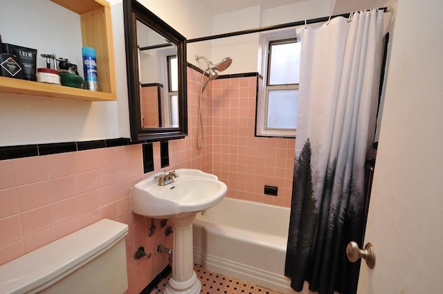 bathroom featuring shower / bath combo, tile walls, and toilet