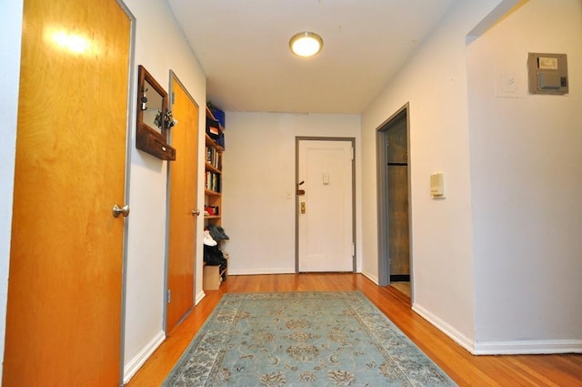 hallway with hardwood / wood-style flooring