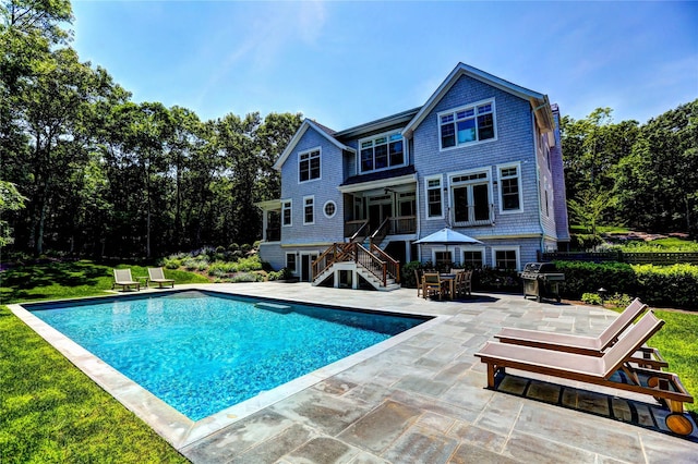 view of swimming pool featuring a patio and grilling area