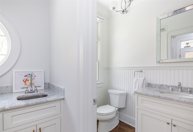 bathroom featuring wood-type flooring, vanity, and toilet