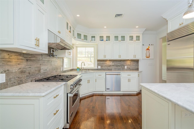 kitchen featuring light stone countertops, sink, premium appliances, crown molding, and white cabinets