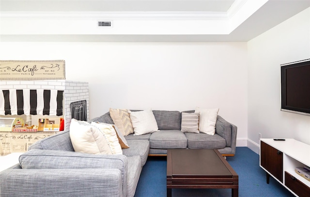 living room featuring a fireplace, dark carpet, and ornamental molding