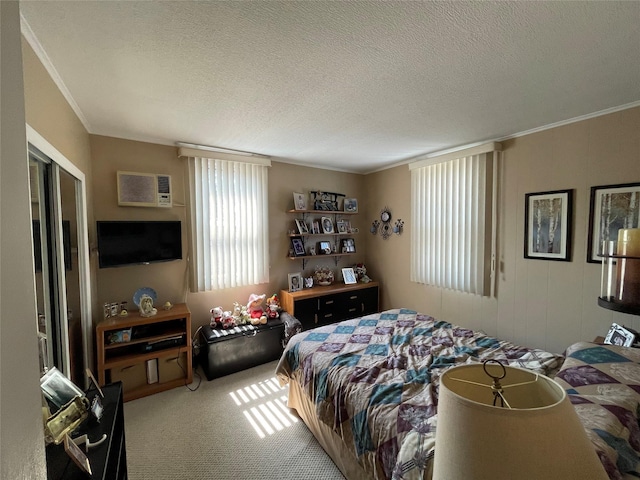 bedroom with a wall mounted air conditioner, carpet, a textured ceiling, and ornamental molding