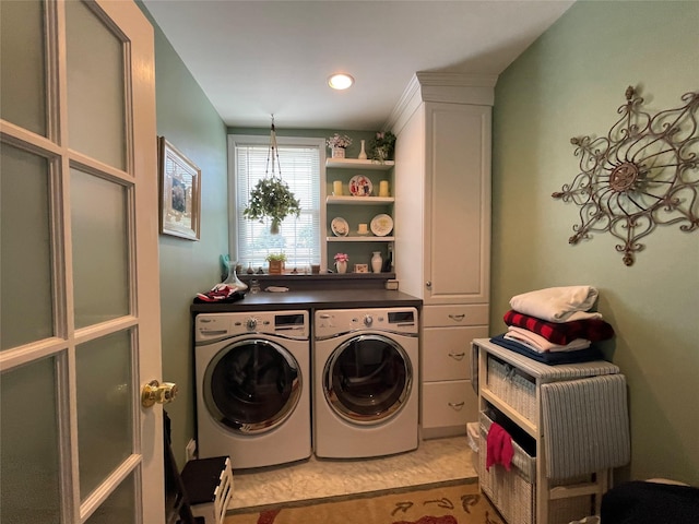 clothes washing area with washer and clothes dryer, cabinets, and light carpet