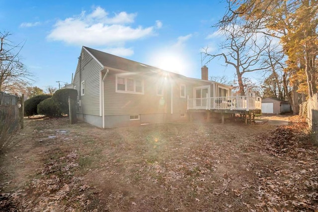 rear view of property with a wooden deck and an outdoor structure