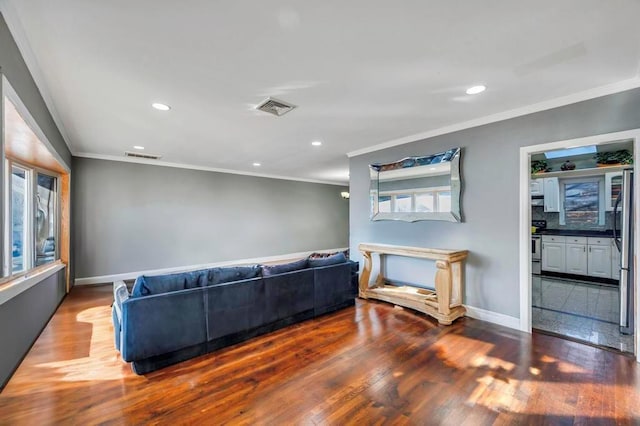 living room with a healthy amount of sunlight, dark hardwood / wood-style flooring, and crown molding