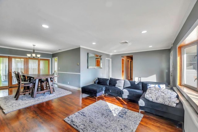 living room with a chandelier, dark hardwood / wood-style flooring, and crown molding