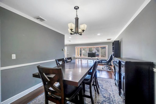 dining area featuring dark hardwood / wood-style flooring, crown molding, and an inviting chandelier