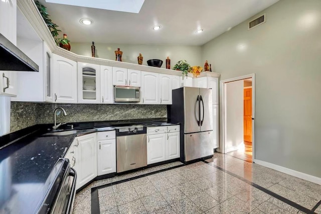 kitchen with sink, ventilation hood, backsplash, white cabinets, and appliances with stainless steel finishes