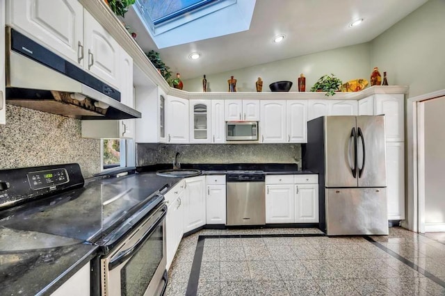 kitchen with white cabinetry, sink, stainless steel appliances, backsplash, and vaulted ceiling with skylight