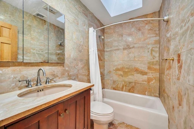 full bathroom featuring a skylight, tasteful backsplash, tile walls, toilet, and shower / tub combo