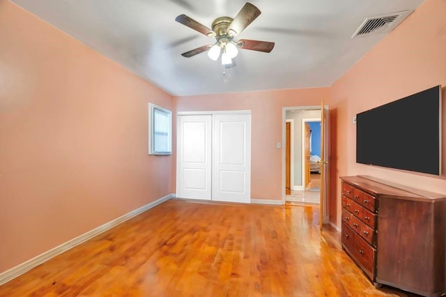 unfurnished bedroom featuring ceiling fan, a closet, and light hardwood / wood-style flooring